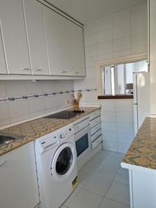 a white kitchen with a washing machine in it at Ola Blanca Carihuela Apartamento in Torremolinos