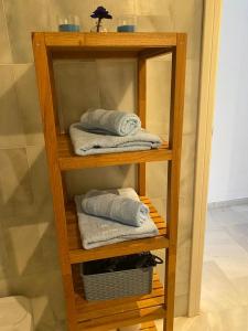 estante de madera con toallas en el baño en Ola Blanca Carihuela Apartamento, en Torremolinos
