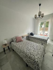 a bedroom with a bed and a couch and a window at Ola Blanca Carihuela Apartamento in Torremolinos