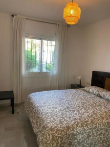 Un dormitorio con una cama grande y una ventana en Ola Blanca Carihuela Apartamento, en Torremolinos