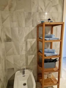 a bathroom with a toilet and a shelf with towels at Ola Blanca Carihuela Apartamento in Torremolinos