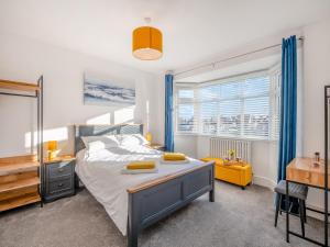 a bedroom with a bed and a desk and window at Coastal Gem in Holland-on-Sea