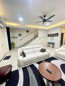 ein Wohnzimmer mit einem weißen Sofa und einem Deckenventilator in der Unterkunft HANZ HOMESTAY MELAKA - MUSLIM HOMESTAY UNIT 3 in Malakka