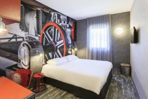 a hotel room with a bed and a wheel wall at ibis Styles Vierzon in Vierzon