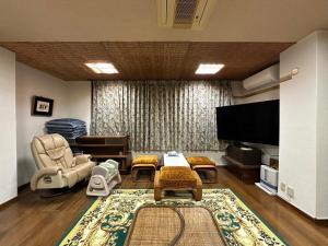 沼津的住宿－Marina bay Numazu マリーナベイ沼津 BBQ可，客厅配有家具和平面电视。
