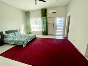 a living room with a red rug and a bed at HANZ HOMESTAY MELAKA 3 - For Muslim in Melaka