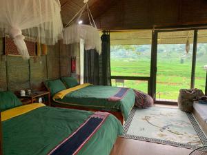 a room with two beds and a large window at May Homestay in Lao Cai