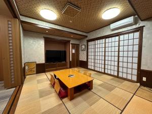 a large room with a table and a tv in it at Minato Oasis Numazu / 沼津観光の中心、伊豆観光の拠点に好立地！沼津港に位置し交通・飲食・コンビニ等至便です！ in Numazu