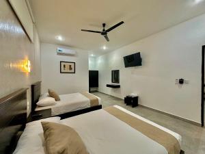 a bedroom with two beds and a ceiling fan at Hotel Zibahun in Valladolid