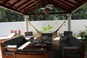 een patio met een tafel en stoelen en een hangmat bij Casa Cuatro Vientos in Tulum