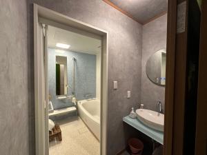 a bathroom with a tub and a sink and a bath tub at Numazu Ikyuuan 沼津一休庵 in Numazu