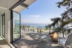 um pátio com cadeiras e uma fogueira e o oceano em Beachfront Luxury Suite #21 at THE BEACH HOUSE em Campbell River