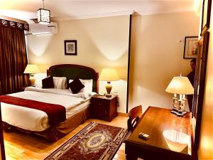 una camera d'albergo con letto, tavolo e scrivania di PYRAMIDS TOWER Inn a Il Cairo