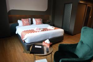 um quarto de hotel com uma cama, uma mesa e uma cadeira em NW 4896 Theater Hotel em Ban Khlong Phruan