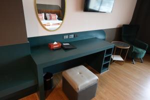 a dressing table with a mirror and a stool at NW 4896 Theater Hotel in Ban Khlong Phruan