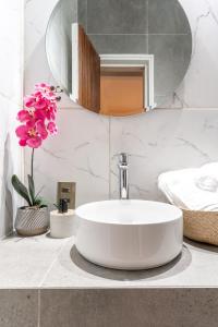 uma casa de banho com lavatório, espelho e flores em Lodge Pochoco Refugio de Montaña em Santiago