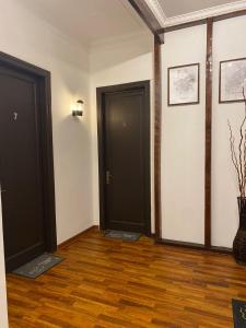 two black doors in a room with wood floors at Hostal El Raco in Santiago