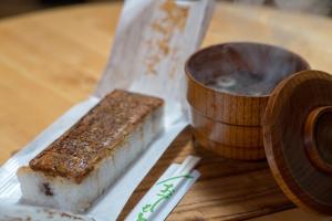a piece of sushi on a table next to a bowl at Tsushima Miuda Pension in Tsushima