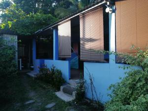 a house with blue walls and a fence at Hostal Niña Oly in Tamanique