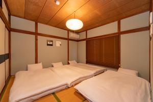 2 łóżka pojedyncze w pokoju z sufitem w obiekcie GuestHouse　YOU&I平和島 w Tokio