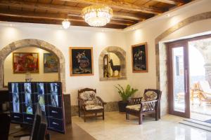 Habitación con sillas y pinturas en las paredes. en Llamita Hotel-Huancayo, en Huancayo
