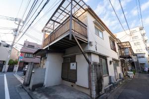 um edifício com uma escada ao lado em GuestHouse　YOU&I平和島 em Tóquio
