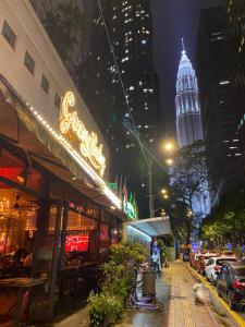 a city street at night with a tall building at KLCC by SWITZHOME in Kuala Lumpur