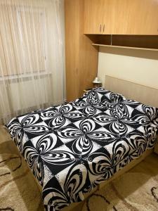 a black and white bed in a room at Apartament regim hotelier Deva in Deva