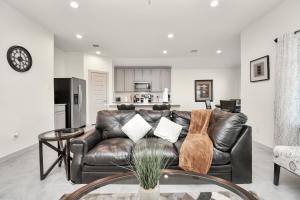 a living room with a leather couch and a table at Exquisite 3 Bedroom Home in Katy in Katy