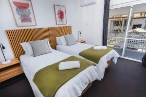 2 łóżka w pokoju hotelowym z oknem w obiekcie Escape Life @ Port Douglas w mieście Port Douglas