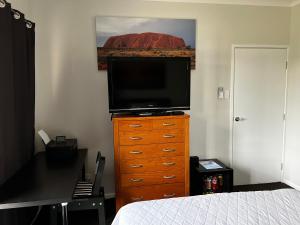 a bedroom with a television on top of a dresser at The Summer Lakeside Room in North Lakes
