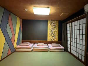 a room with two beds in a room with a window at Minato Oasis Numazu / 沼津観光の中心、伊豆観光の拠点に好立地！沼津港に位置し交通・飲食・コンビニ等至便です！ in Numazu