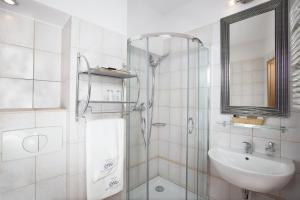 W łazience znajduje się prysznic, umywalka i lustro. w obiekcie Comfort by Trio w mieście Białystok