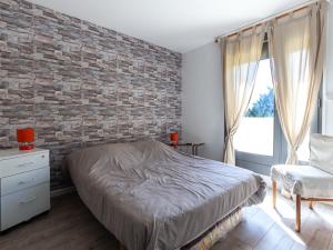 a bedroom with a brick wall and a bed and a chair at Appartement Seignosse, 3 pièces, 4 personnes - FR-1-239-463 in Seignosse