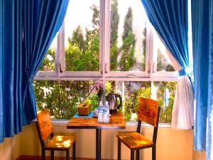 a table and two chairs in front of a window at Tùng Garden Homestay Dalat in Xuan An