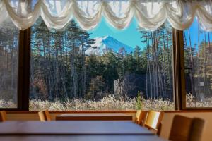 a room with a view of a mountain through a window at Fujinomori Hotel in Fujikawaguchiko