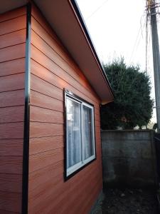 una ventana en el lateral de un edificio rojo en Mini cabaña nueva independiente, en Temuco