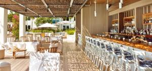 a restaurant with white tables and chairs and a bar at Stunning Studio with Balcony in South Beach in Miami Beach