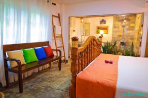 a bedroom with two chairs and a bed with colorful pillows at Subhasha Summer House in Talalla