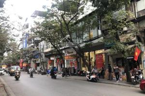 a busy city street with people riding motorcycles down the street at Little Hanoi Hostel in Hanoi