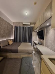 TjilandakにあるMashley Room Prestige Apartment SKY HOUSE BSDのベッドルーム(ベッド1台、ベンチ付)