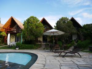 グラヴァターにあるChalé na Suíça Pernambucanaのビリヤード、テーブル、傘が備わる家