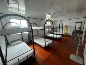 a room with three bunk beds and a mirror at Mabul Backpackers in Pulau Mabul 