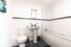 a white bathroom with a toilet and a sink at Amaryllis- 2 Bedroom Flat in Southampton