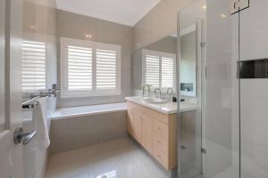 a bathroom with a tub and a sink and a shower at The Noosa Haven Luxe Waterfront Home in Noosaville +11 photos