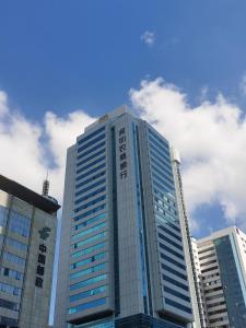 a tall building with a sign on top of it at Yutai Hotel Apartment in Shenzhen