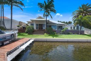 a house with a pond in front of it at The Noosa Haven Luxe Waterfront Home in Noosaville