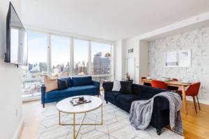 a living room with a blue couch and a table at Super Luxury Penthouse 3bd 3bath in Jersey City