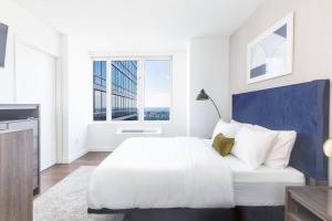 a white bedroom with a large bed and windows at Super Luxury Penthouse 3bd 3bath in Jersey City
