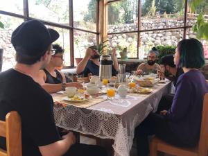 un grupo de personas sentadas alrededor de una mesa comiendo comida en Spirit Of The River Lodge, en Cusco